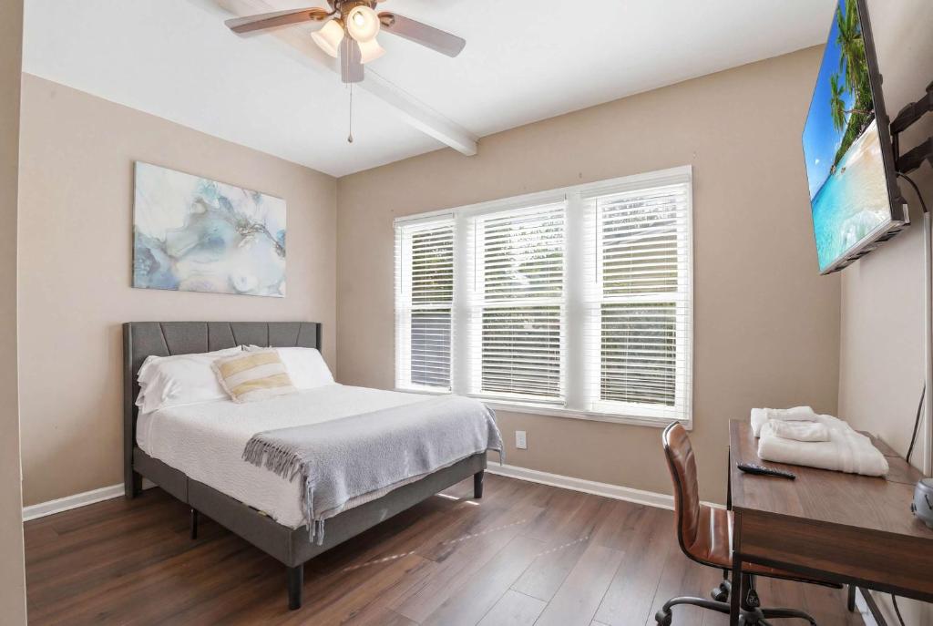 a bedroom with a bed and a desk and a television at Group-Ready 6BR Gem in Central Lafayette in Lafayette