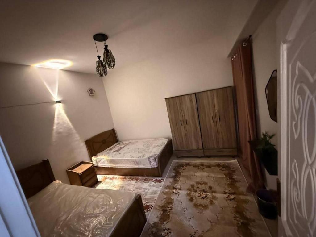a bedroom with two beds and a dresser at Abu sobh holiday in Alexandria