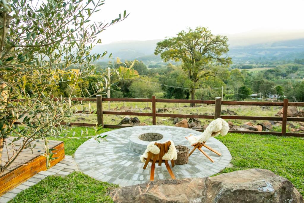 a garden with a circular table in the grass at Encosta do Café - Chalé Oliveira in Itati