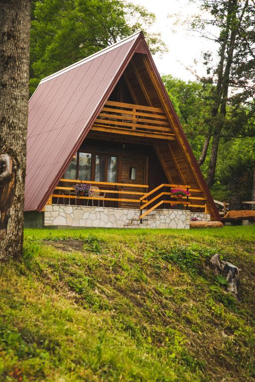 a small cabin with a red roof in a forest at Poscenje in Šavnik