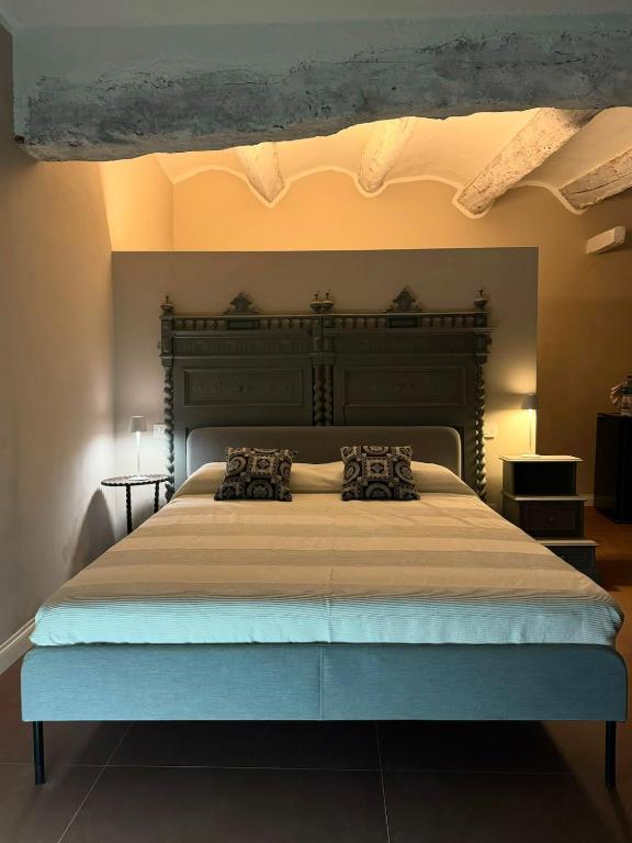 a bedroom with a large bed with a large headboard at Villa Lu alloggio con idromassaggio e piscina in Carignano