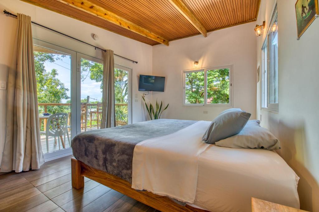 a bedroom with a bed in a room with windows at Bocas Stoked Monkeys in Bocas Town