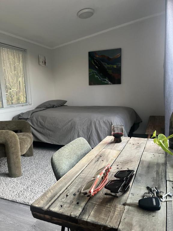 a wooden table in a living room with a bed at Oasis in onerahi in Whangarei