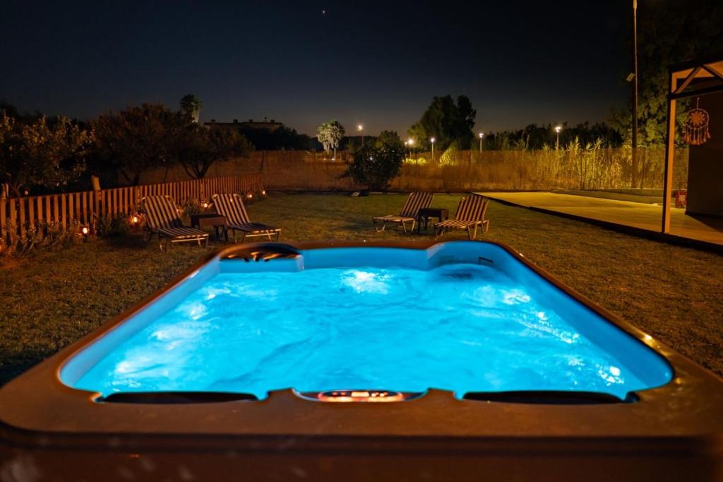 a hot tub in the middle of a yard at night at maison de rivière in Afantou