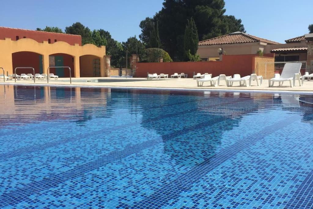 a large swimming pool with white chairs and chairs at Bleu miami in Argelès-sur-Mer
