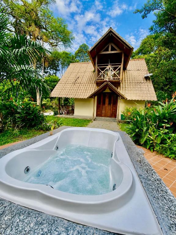 a jacuzzi tub in front of a house at Chalé Suíço - Chalés Belo Monte - Sítio Belo Monte in Pacoti