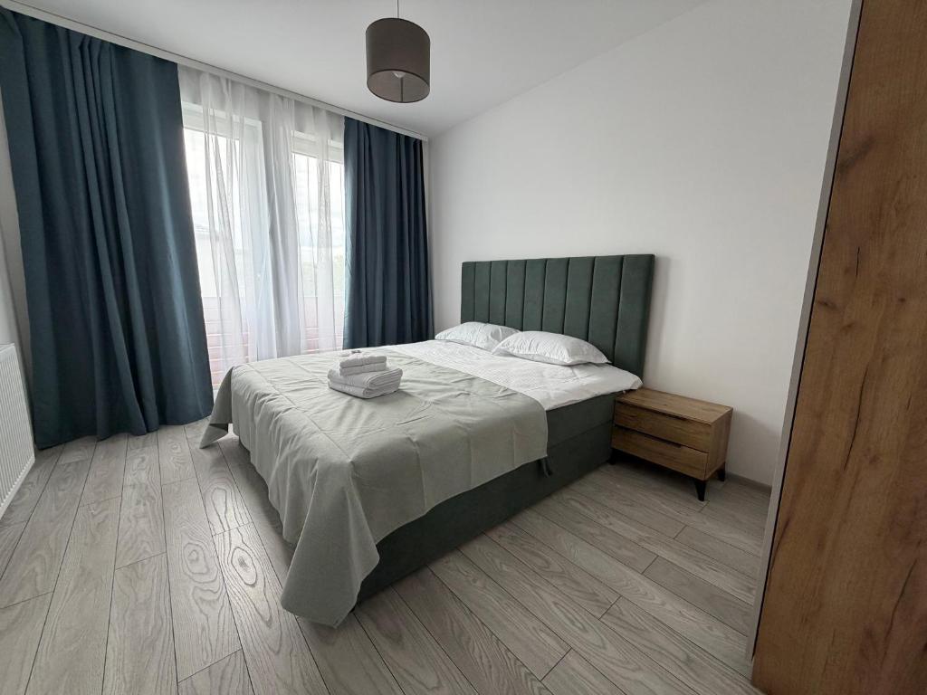 a bedroom with a bed with a green headboard at Concept Residence in Târgu-Mureş