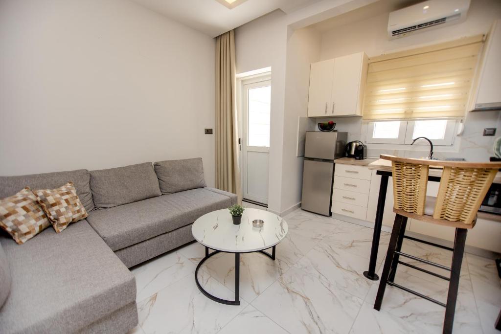 a living room with a couch and a table and a kitchen at Room12 in Stavros