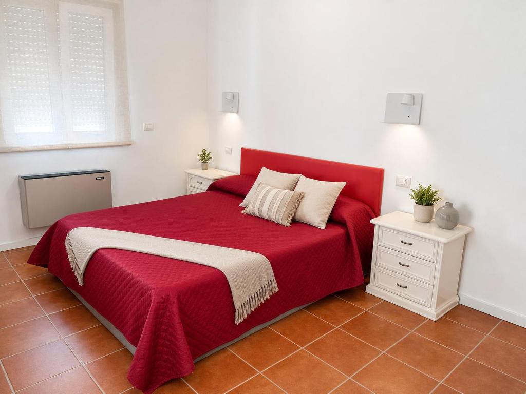 a bedroom with a red bed with two night stands at Affaccio degli Dei in Drapia