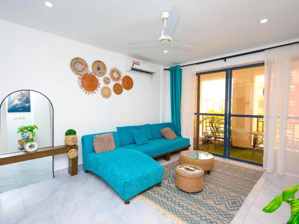 a living room with a blue couch and a window at Chui de eagle in Mombasa