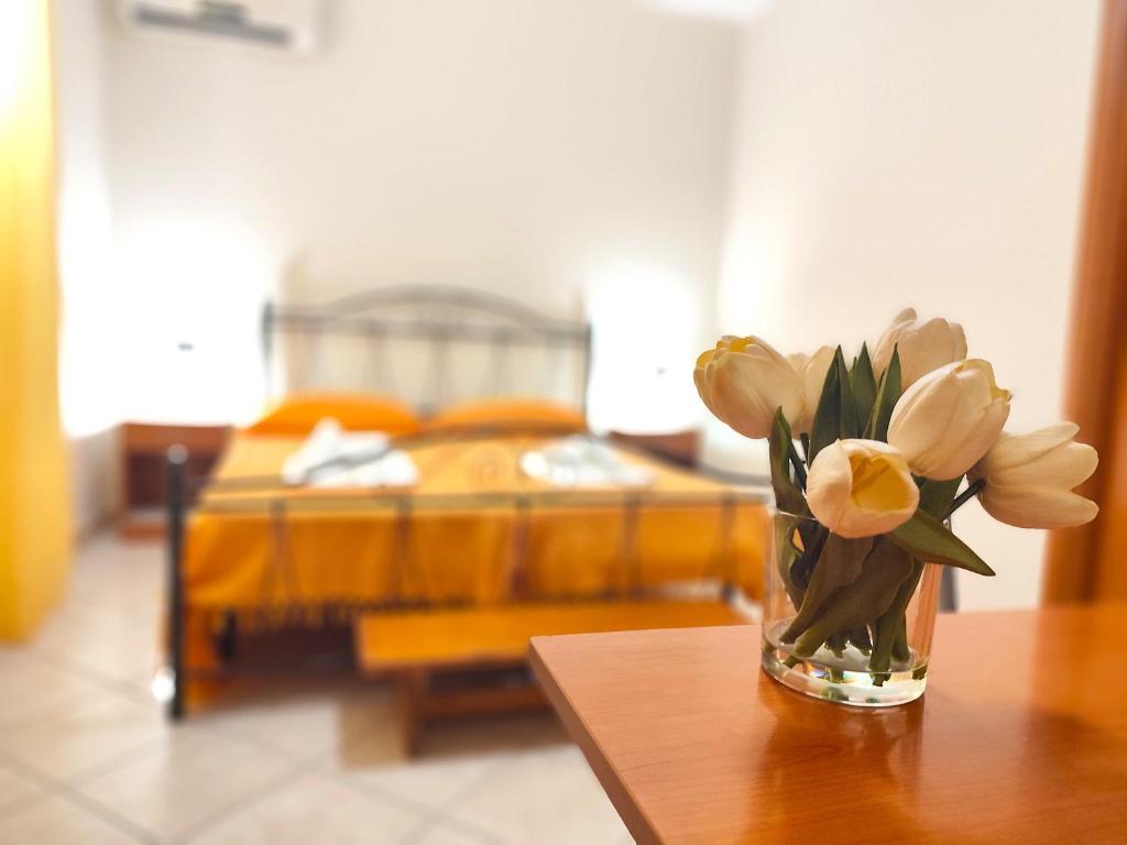 a vase of flowers on a table in a bedroom at B&B Profumo di Zagara in Taormina