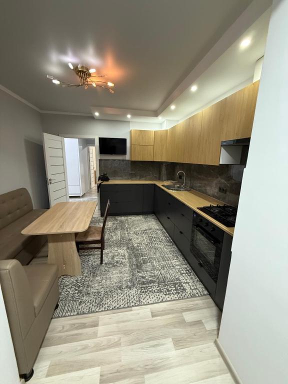 a kitchen with a wooden table and a dining room at Квартира в центре города in Komrat