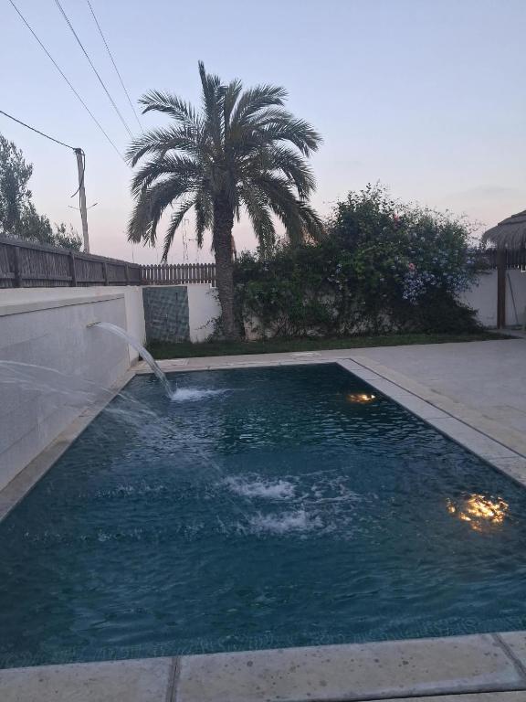 a small pool of water with a fountain at Dar sirine in Arkou