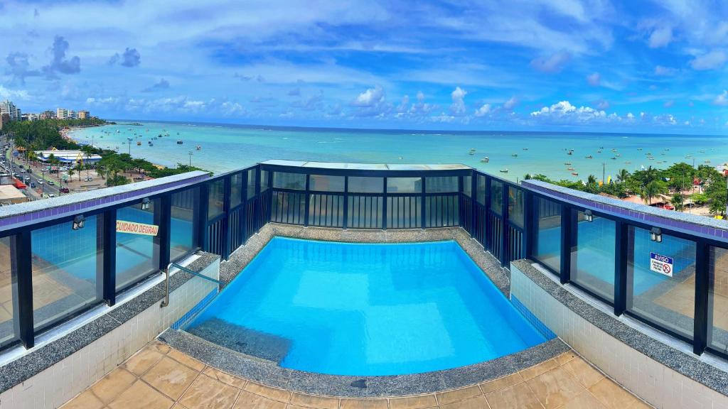 a swimming pool on top of a building with the ocean at Vacanze - Neo in Maceió