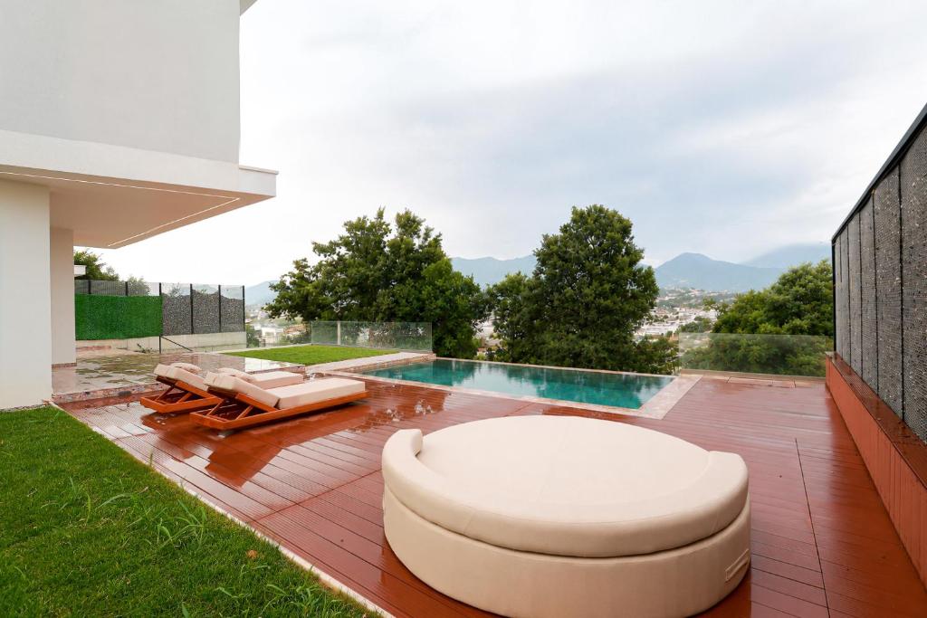 a backyard with a swimming pool and lounge chairs at Hilltop Villa Tirana in Mjull-Bethore