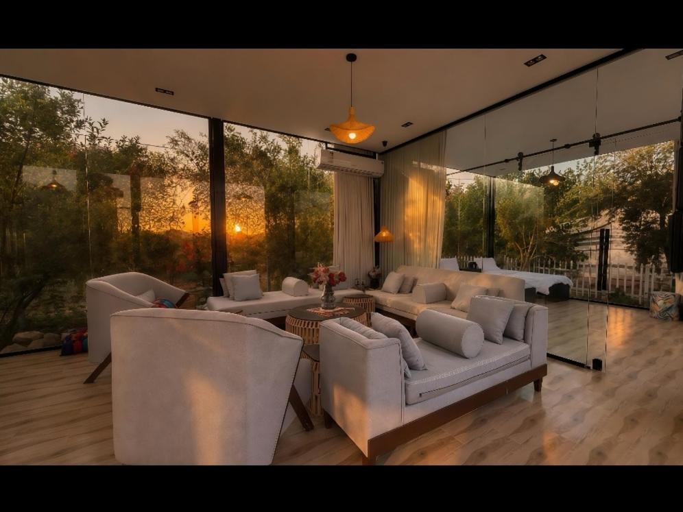 a living room with white furniture and large windows at منتجع سفاري ديور in At Turbīyah