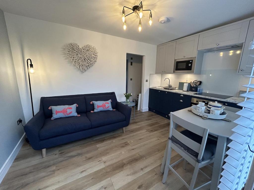 a living room with a blue couch and a kitchen at SeaStar Dartmouth in Dartmouth