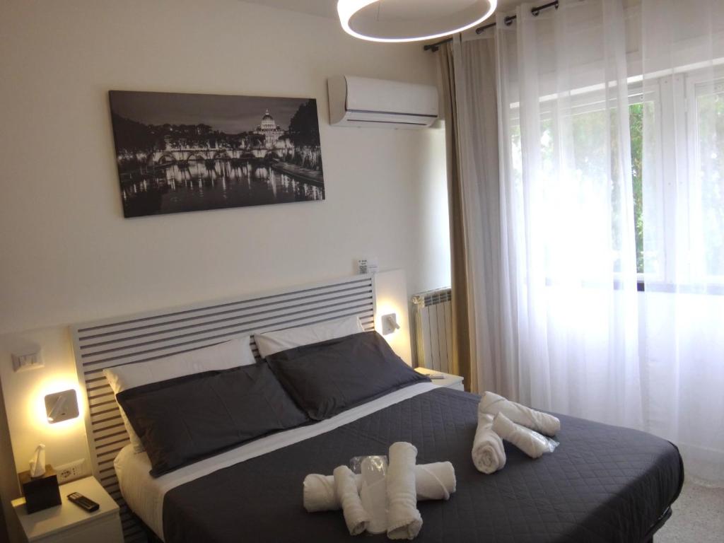 a bedroom with a bed with two towels on it at Urban Rifugio - Camera privata con bagno vicino EUR in Rome
