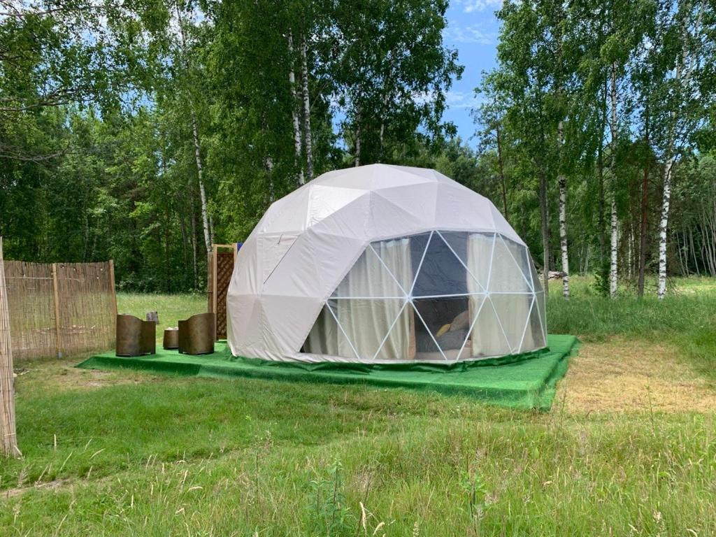 a tent in the middle of a field at Couple Luxury Villa in Apšuciems
