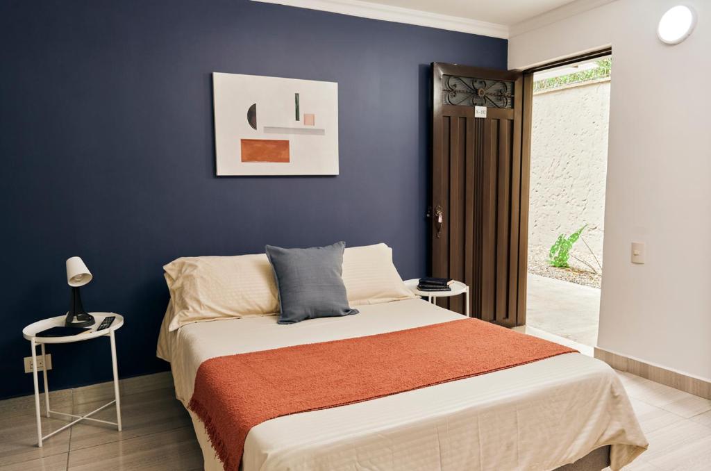 a bedroom with a bed and a blue wall at Poblado-Aguacatala Apart-Hotel in Envigado