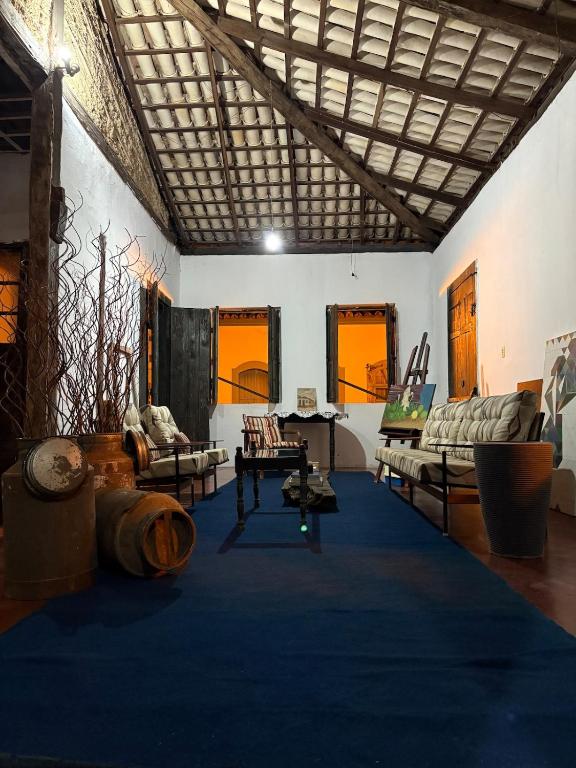a living room with couches and a blue rug at Casa Beco do Sertão - Praça do Coreto in Goiás