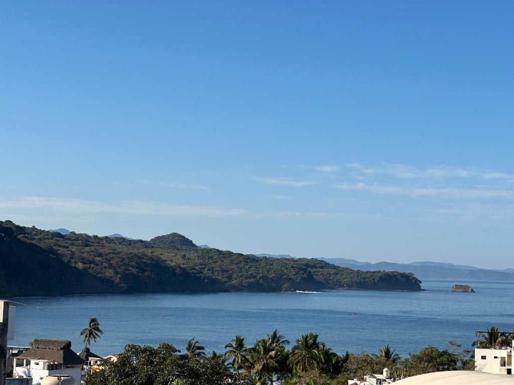 a view of a large body of water with palm trees at Casa Maracuyá Chacala in Chacala
