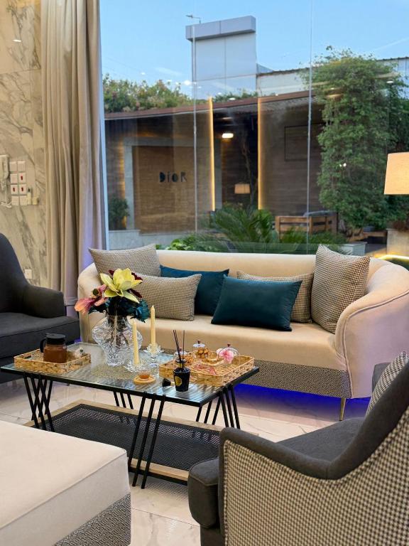 a living room with a couch and a table at شالية ديور الفندقي in Al Wudayy