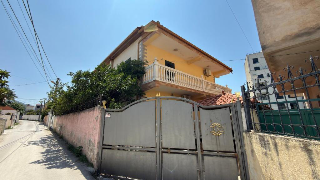 a house with a gate in front of a house at Gioele apartament in Vlorë