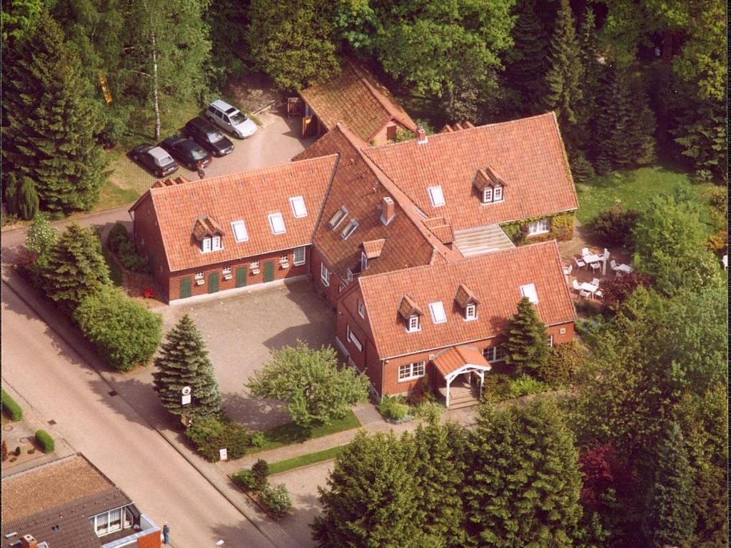 einen Blick über ein großes Haus mit parkenden Autos in der Unterkunft Cafe Gaubenhaus in Bad Fallingbostel