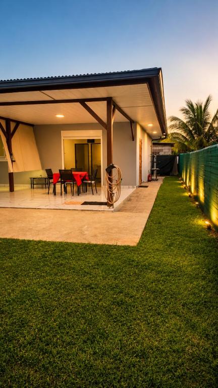 a house with a patio with red chairs and a fence at Coeur A 2 in Macouria