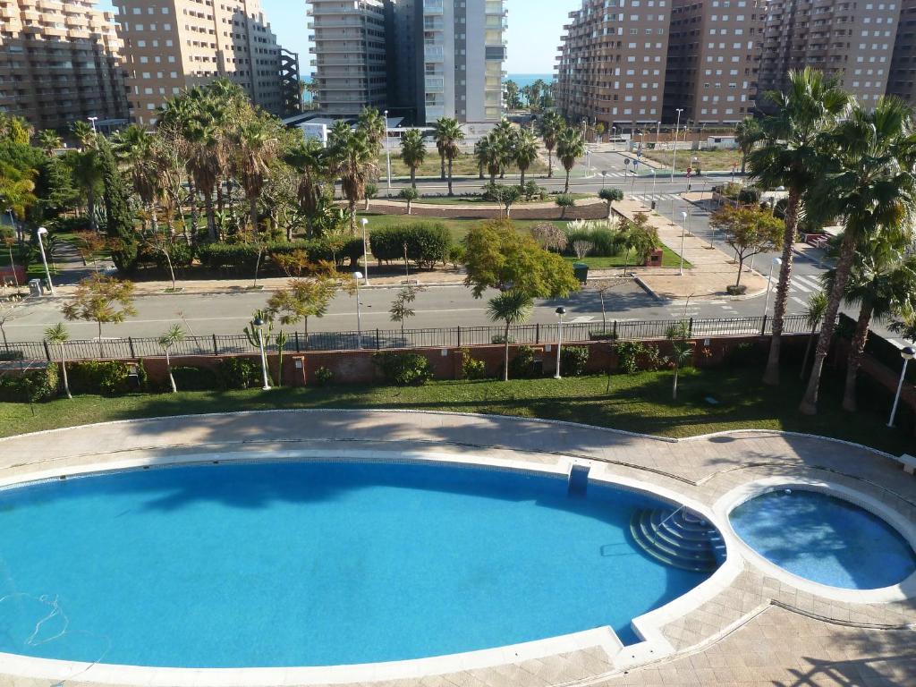 una piscina vacía en un parque con edificios al fondo en Playa Coral en Marina D'or, en Oropesa del Mar