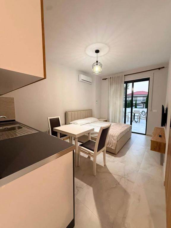 a kitchen and living room with a table and a bed at Coastal Pine Appartment in Golem