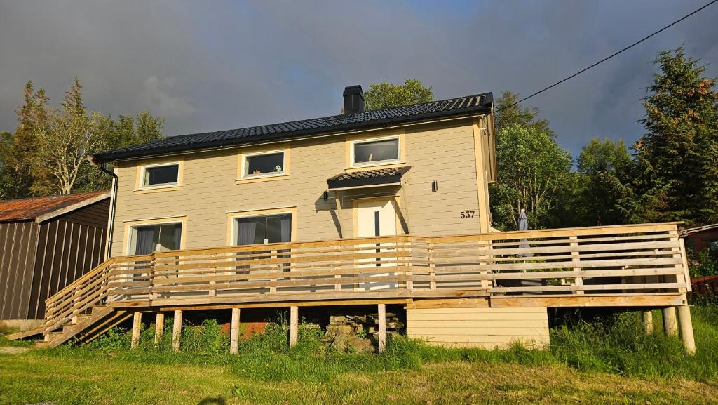 a house being constructed with a large wooden deck at Fjordhuset på Helgelanskysten in Leirfjord