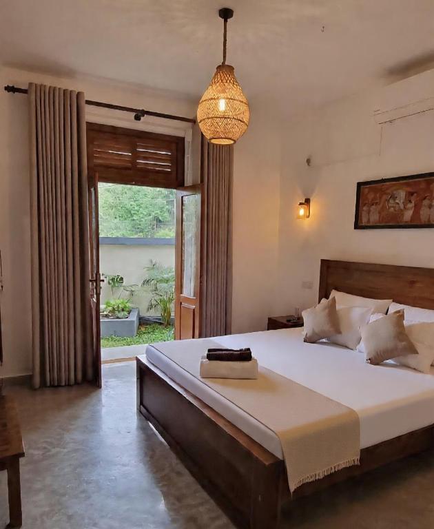 a bedroom with a large bed and a pendant light at Moksha Villa-Hostel Kandy in Kandy
