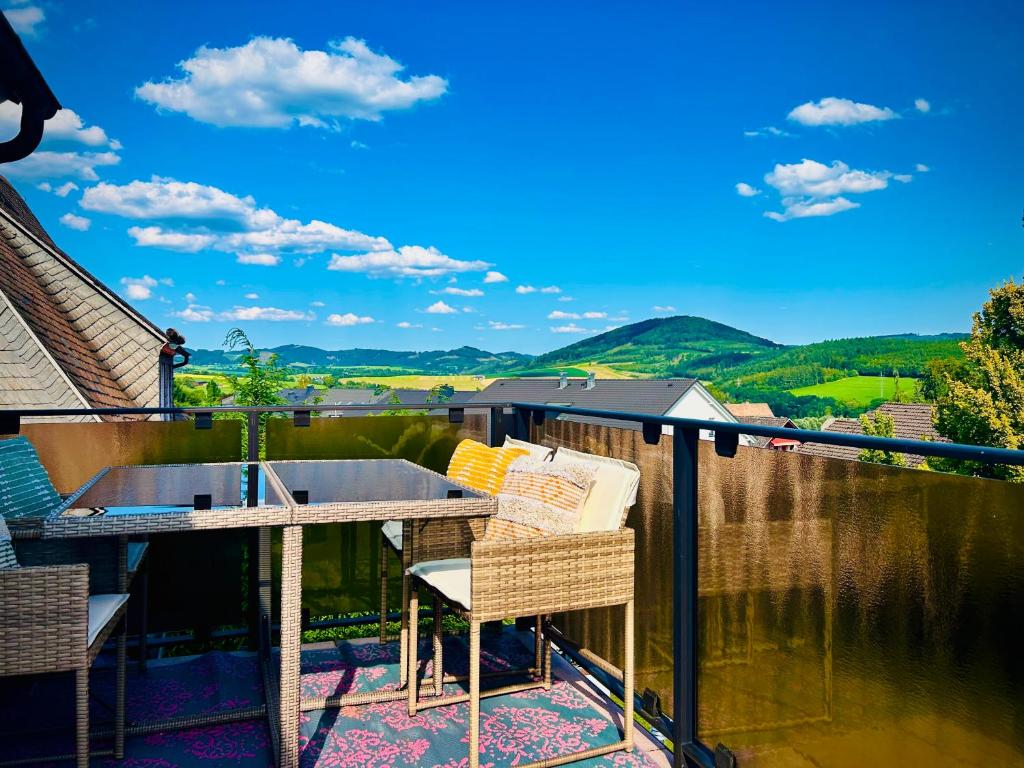 a patio with a table and chairs on a balcony at Panorama Joy - stilvolle Gemütlichkeit mit Weitblick in Schmallenberg