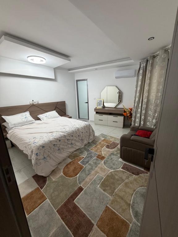 a bedroom with a bed and a chair and a mirror at Résidence sauver in Abidjan
