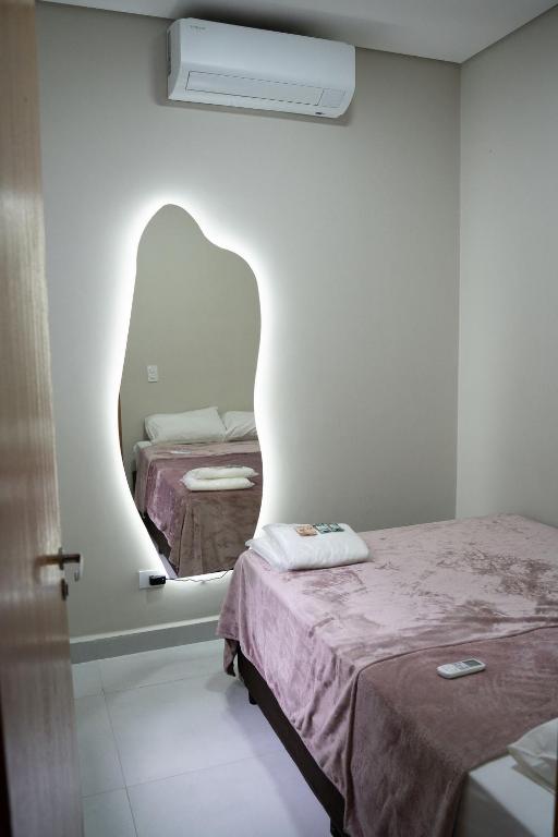 a room with two beds and a mirror on the wall at Casa 2 Quartos com Ar até 8 Pessoas Jd. Sabiás in Indaiatuba