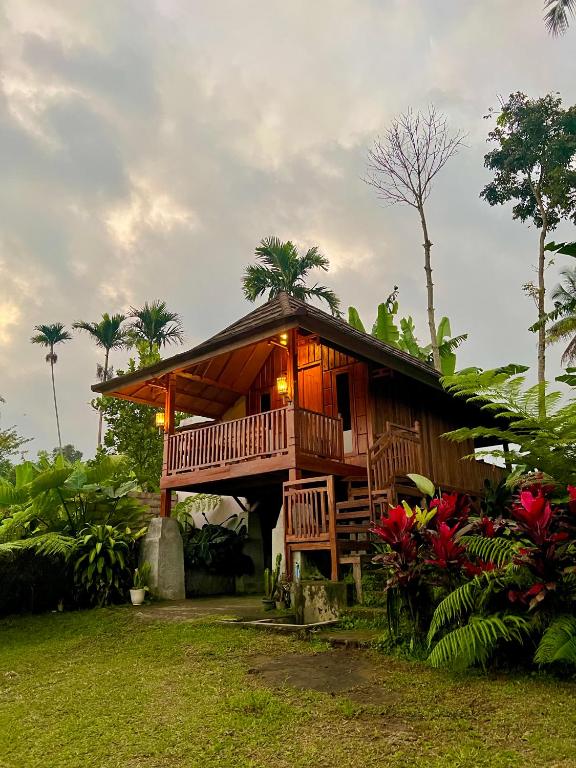 a wooden house with a porch and some plants at Dopi Rinjani Homestay in Tetebatu
