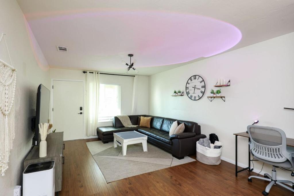 a living room with a couch and a clock on the wall at The Mira Mesa Gamezone in San Diego