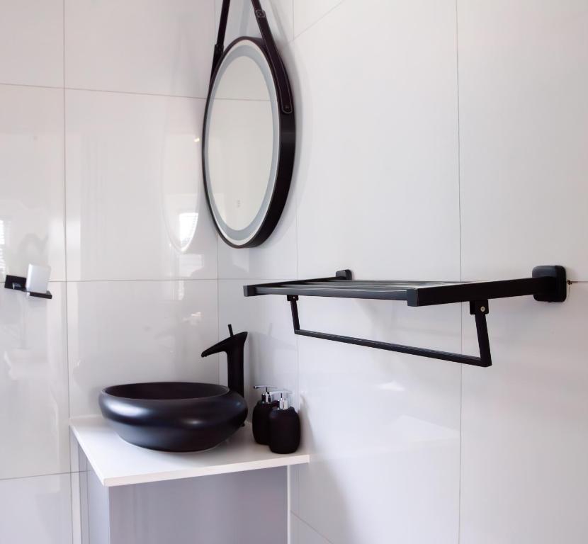 a bathroom with a black toilet and a mirror at Ipanima palace in New Germany