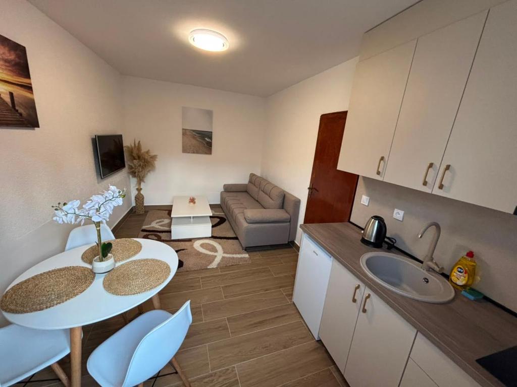a kitchen and living room with a table and a couch at Aurea Novi 3 in Herceg-Novi