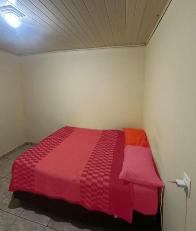 a bedroom with a red and pink bed in a room at Destiny home in Curitiba