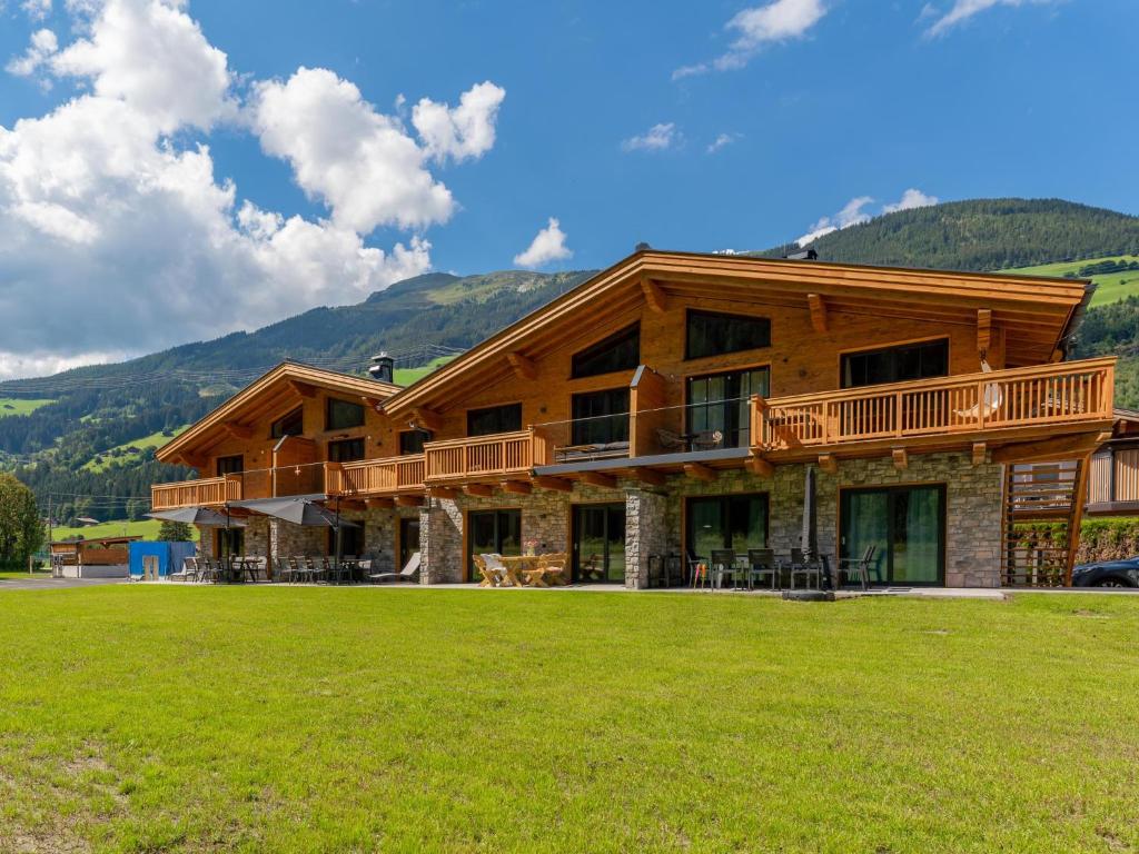 a large log cabin with a lawn in front of it at Almrausch in Wald im Pinzgau