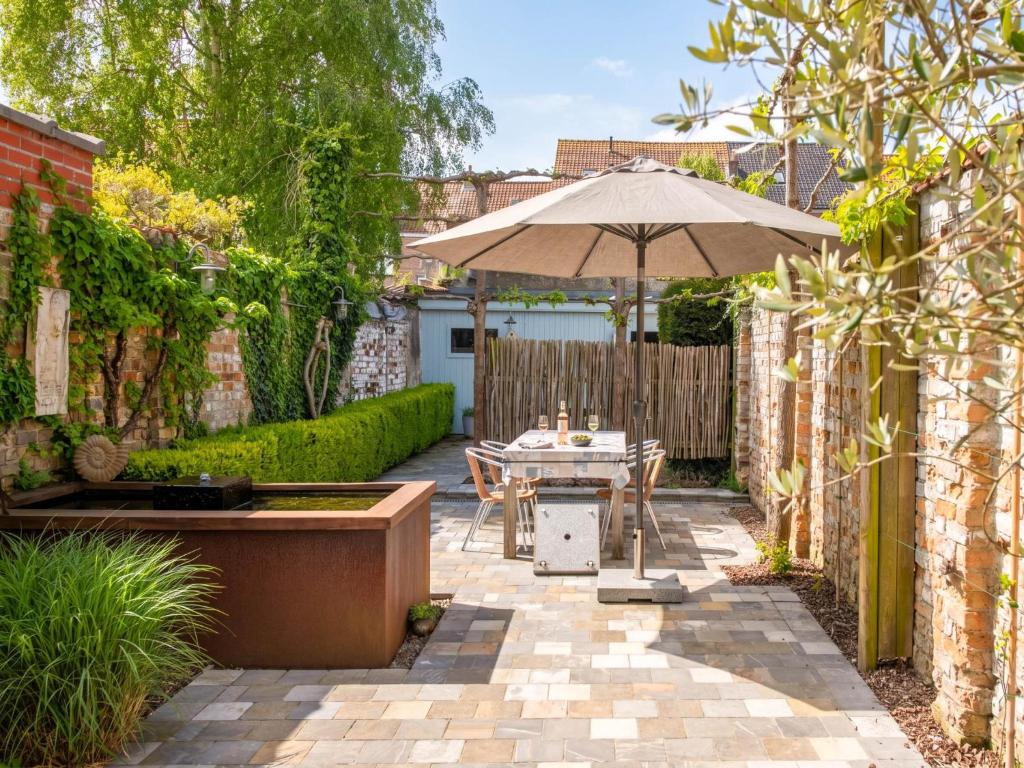 a patio with a table and an umbrella at Tuzzetje in Nieuwpoort