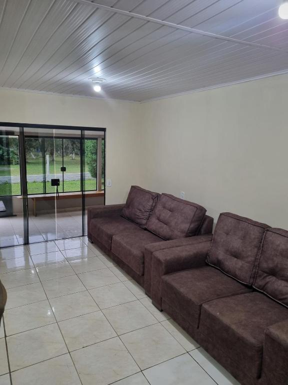a living room with a couch and a table at Casa Da Chácara in Prudentópolis