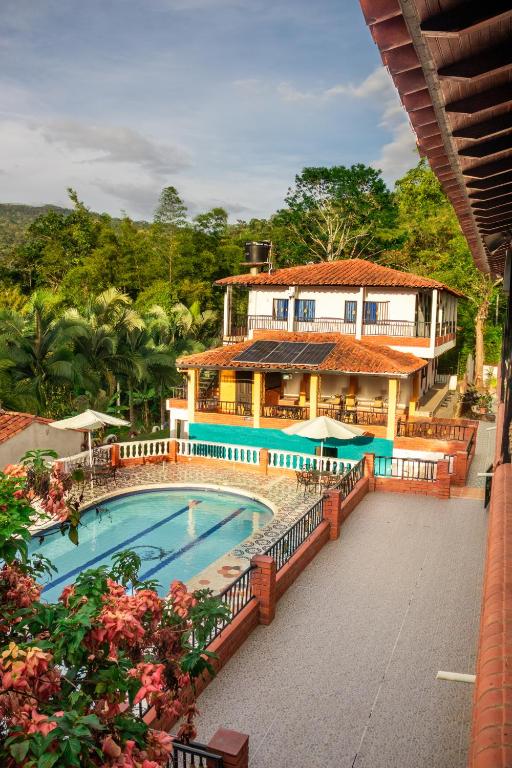 a resort with a swimming pool and a building at Hotel para descanso con piscina in San Gil