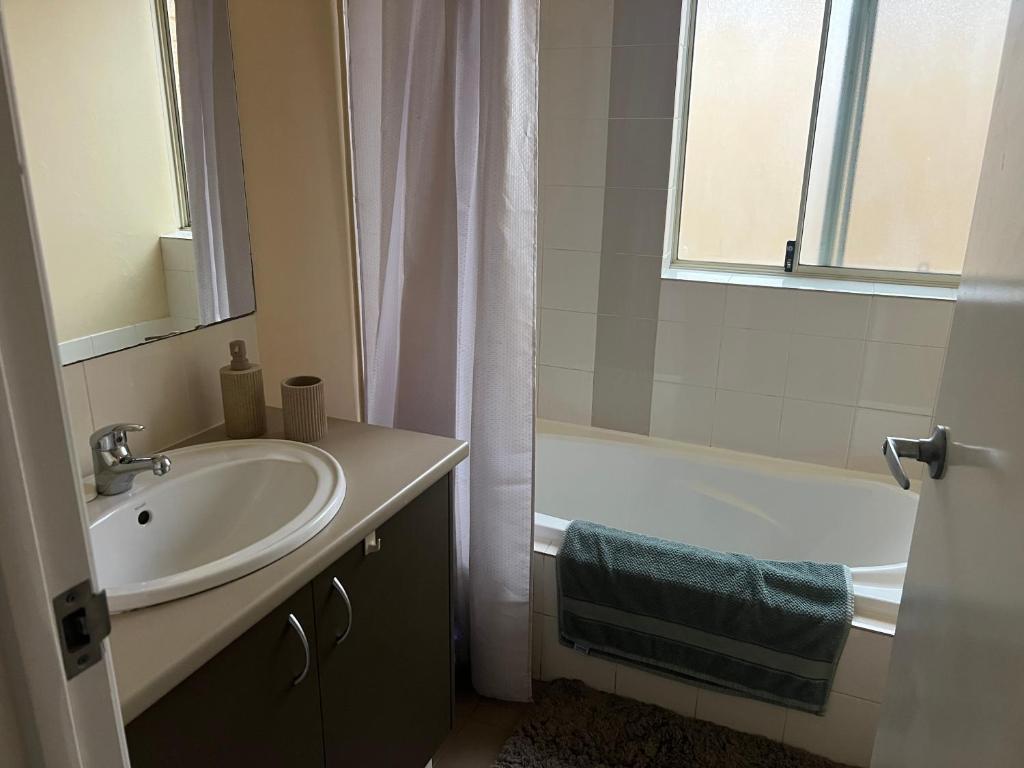 a bathroom with a sink and a bath tub at Sweet Single in Wellard
