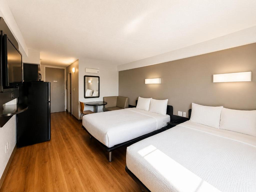 a hotel room with two beds and a table at Studio 6 Springfield VA Washington DC Southwest in Springfield