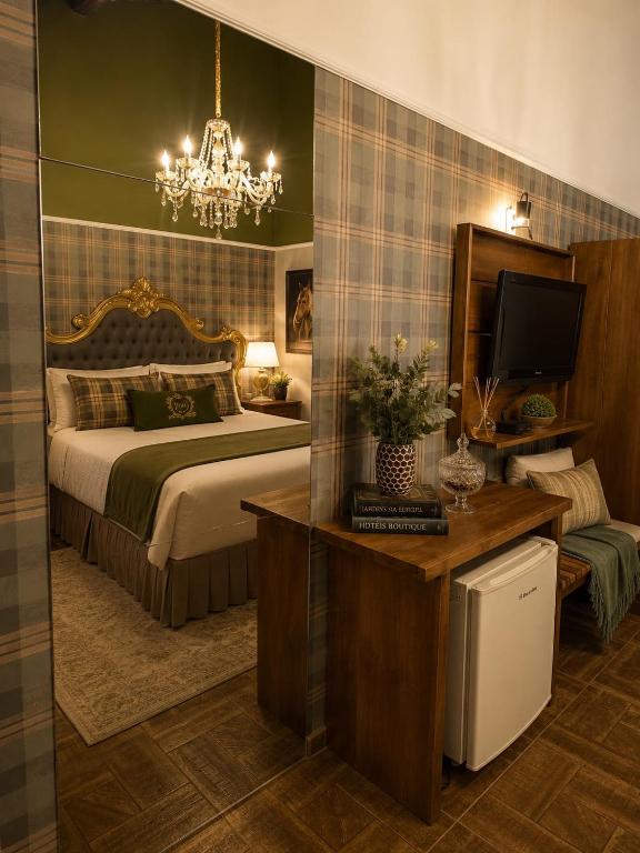 a bedroom with a bed and a desk with a television at Refugio MontSerrat in Urubici