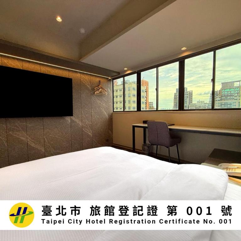 a hotel room with a bed and a flat screen tv at Hub Hotel Ximen-inn Kunming in Taipei